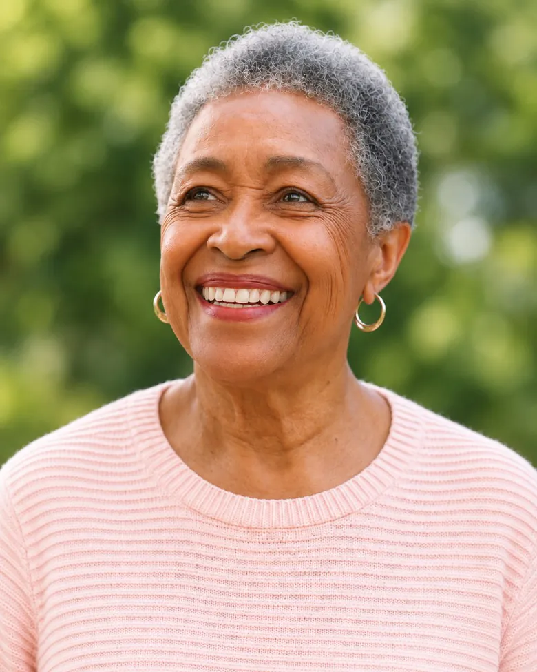 A smiling older woman standing outdoors